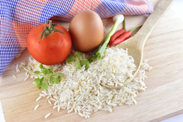 Rice, chilli, onion, egg and tomato on a wooden background