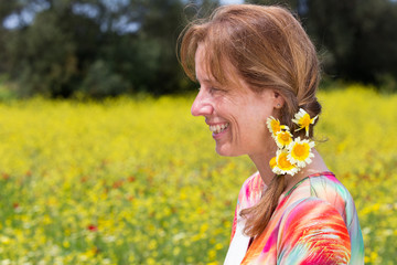 Dutch woman wearing braid with yellow flowers in rapeseed field