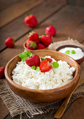 Cottage cheese with strawberries in a wooden bowl