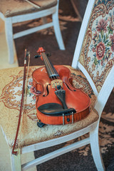 Fototapeta na wymiar Classic music violin vintage close up. Violin on chair