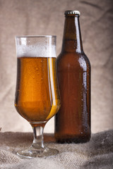 Glass and bottle with beer on the table