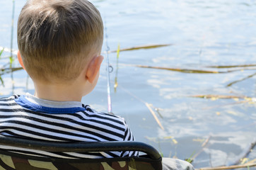Little boy relaxing fishing at a lake