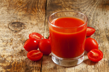 Fresh tomato juice and tomatoes on the table, selective focus