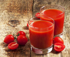 Fresh tomato juice and tomatoes on the table, selective focus
