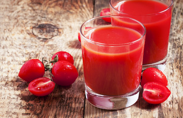Fresh tomato juice and tomatoes on the table, selective focus