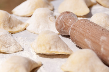 Making traditional food pierogy with dough roller