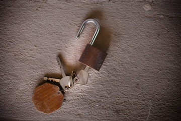 old rusty iron keys on cement background.