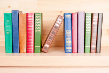 Old books on a wooden shelf