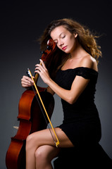 Female musical player against dark background © Elnur