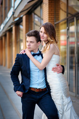 happy bride and groom walking in a city