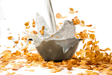 pouring milk into corn flakes creating splash