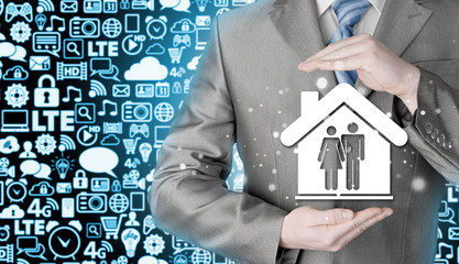 businessman protecting family in home with hands