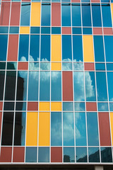 clouds floating in the sky reflected in the glass of skyscraper