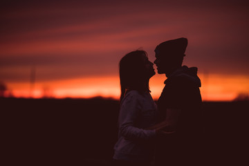 Silhouettes of hugging couple against the sunset 