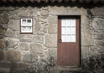a rustic country house with a wooden door and a window