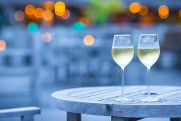 Two glasses of tasty white wine at sunset 