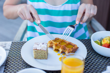Delicious waffles, cake, coffee and juice served for breakfast