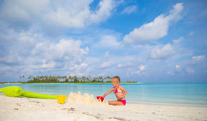 Adorable little girl playing with beach toys during tropical