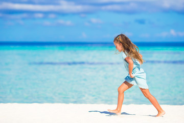 Adorable little girl running on tropical white beach
