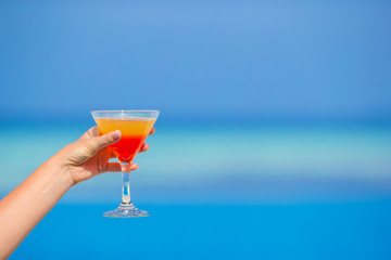 Woman holding cocktail on tropical beach