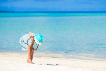 Fototapeta na wymiar Adorable happy little girl in hat on beach vacation