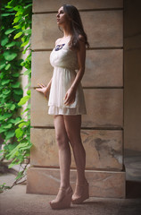 Obraz na płótnie Canvas Beautiful woman with long legs walking outdoors in white dress