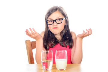 a little girl has a choice between water and milk