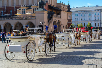 Naklejka premium Horse carriages at main square in Krakow