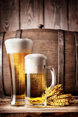 Tall glass and a mug of light beer