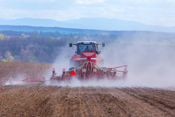 Fototapeta premium Tractor harrowing the field