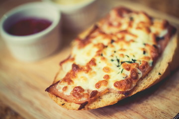 Bread baked with cheese served with tomato sauce, and chili sauc