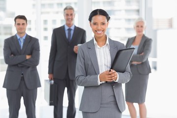 Fototapeta premium Businesswoman with colleagues behind in office
