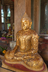 The ancient gold buddha statue sitting and smile