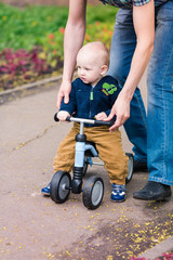 Father teaching baby boy on his first running bike