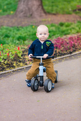 Cute baby boy on his first running bike