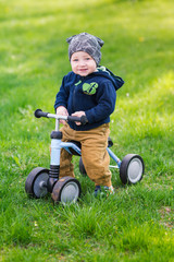 Cute baby boy on his first running bike