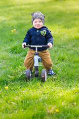 Cute baby boy on his first running bike