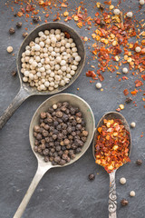 Black pepper corn, white pepper corn and dried chili flakes in o