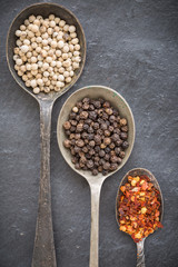 Black pepper corn, white pepper corn and dried chili flakes in o