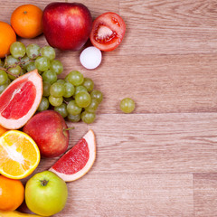 juicy fruits and vegetables on wooden background