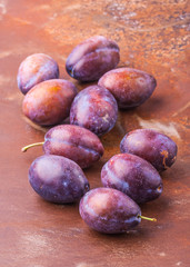 Plums scattered on the metal background