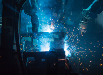 A team of robots welding in automobile parts industry.