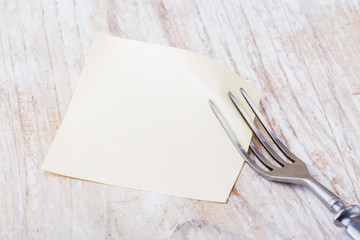 Blank picture frame paper with fork on a wooden table