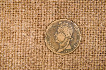 Vintage bronze coin with portrait on the old cloth