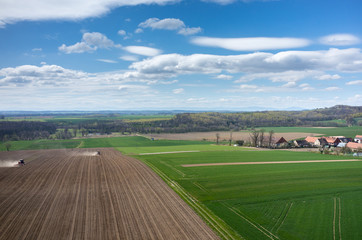 Aerial view of the tractor harrowing the field