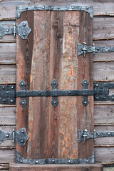 Old wooden door with metal hinges and lock