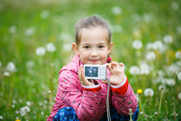 Little smiling girl proudly showing her photograph