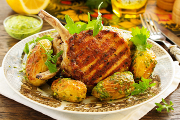 Grilled pork chop on the bone with spicy potatoes.  