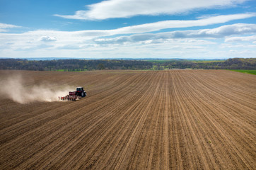 Aerial view of the tractor harrowing the field