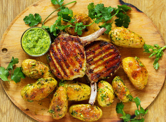 Grilled pork chop on the bone with spicy potatoes.  